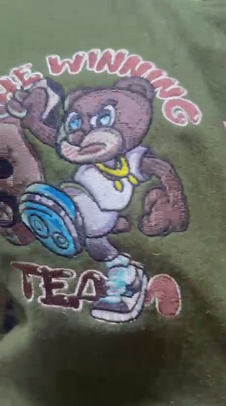 Load video: Original price 250.0 (PRE-ORDER) The Winning Team apparel Varsity Jacket in olive Green and Cream Limited Edition. A tribute to my big sister who passed away from Lupus. The 77 is her birth year 11/11/77 and the color scheme represents our Veterans. In memory of Charita Eason and Veterans Day. A stylish varsity jacket featuring cream leather sleeves with a high quality olive green wool silhouette. It has a unique embroidered patch work design. Perfect for adding a touch of class and style to any outfit. Rather to keep warm or just to be fly. This limited piece offers you the look and opportunity to create your own way. You want to be the creator of fashion, why not be the ONE.”One of one.”